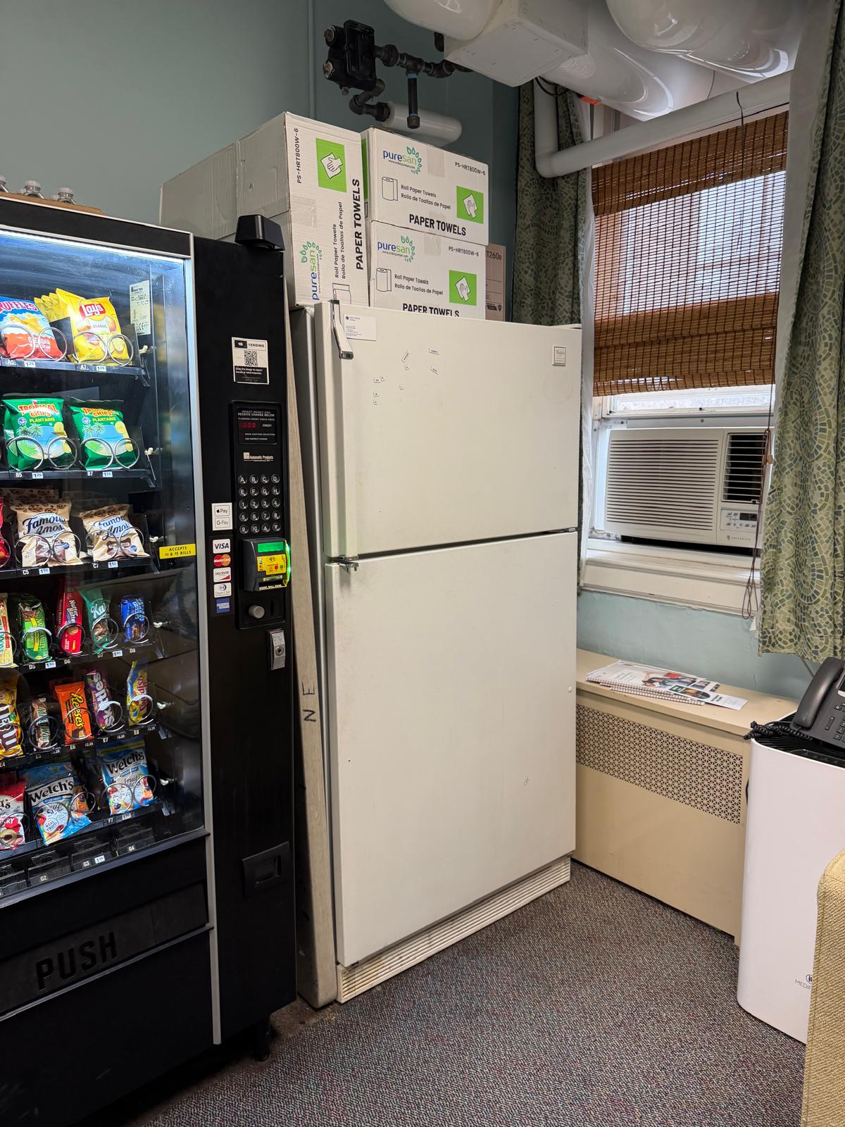 The old, worn refrigerator in the teacher lounge before the refresh